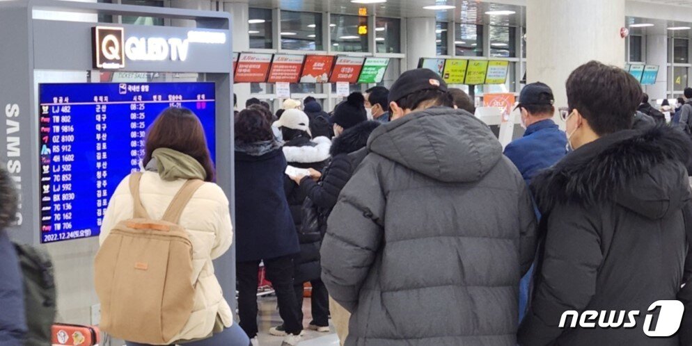 본문 이미지 - 22일부터 제주를 덮친 강풍과 폭설 등으로 끊겼던 제주노선 항공기 운항이 24일 재개되면서 관광객 등이 제주국제공항에 설치된 화면을 통해 운항정보를 확인하고 있다. 2022.12.24/뉴스1 ⓒ News1 강승남 기자