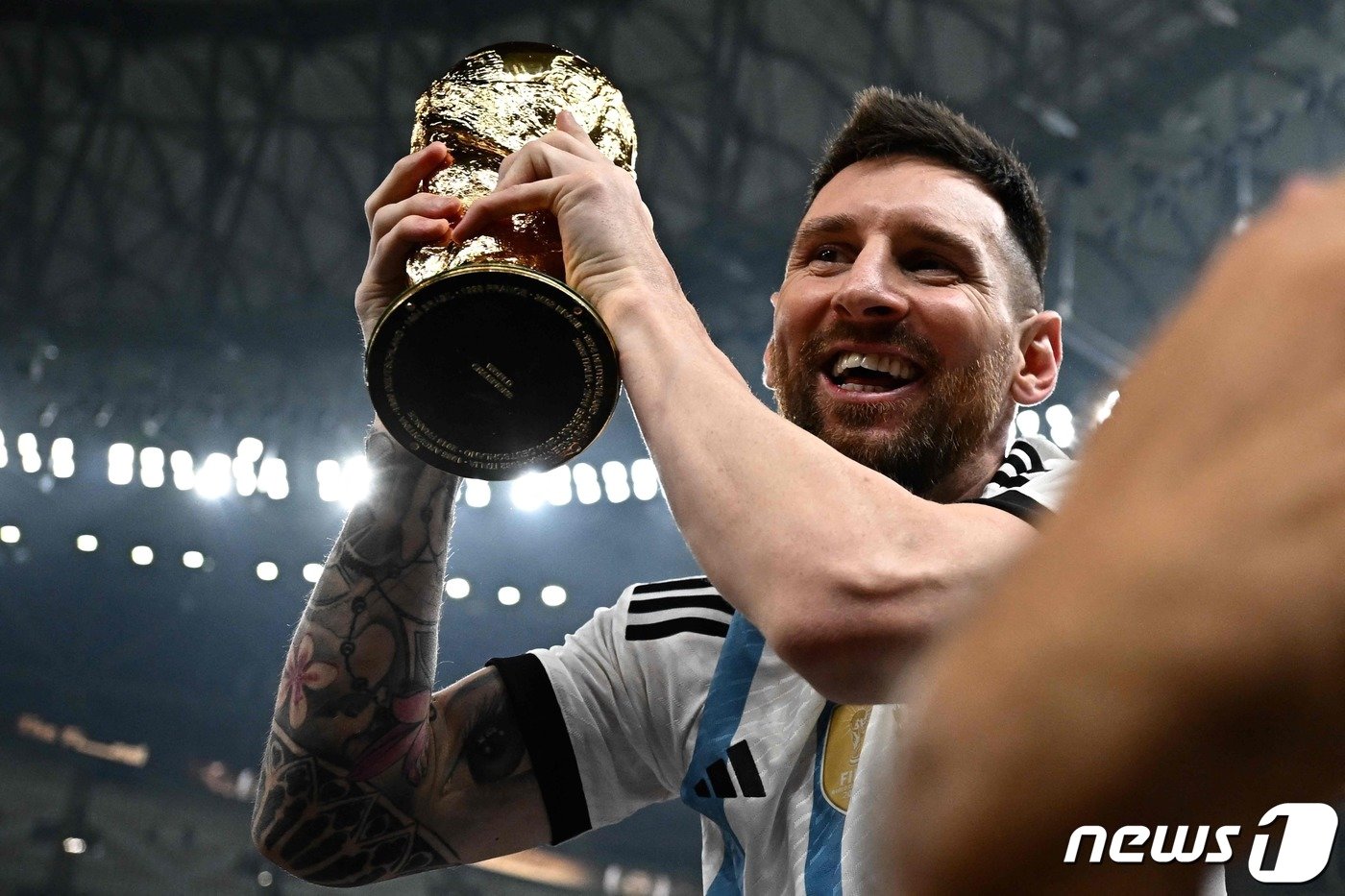 본문 이미지 - 월드컵을 들고 기뻐하는 메시. 2022.12.18. ⓒ AFP=뉴스1