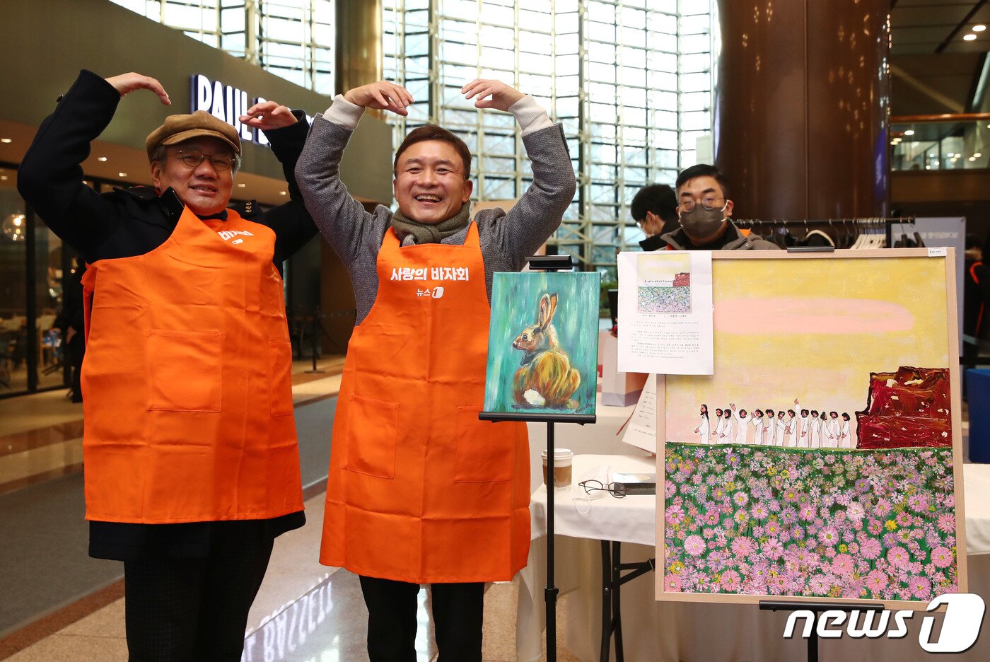 본문 이미지 - 이백규 뉴스1 대표이사(오른쪽), 강호병 전무가 23일 서울 종로구 제일은행 본점 1층에서 열린 2022 뉴스1 사랑의 바자회에서 기증된 미술품 옆에서 포즈를 취하고 있다. 왼쪽그림은 식품기업 하림 김홍국 회장이  기증한 김세연 작가의  '토끼숲  나거기 있나요' 작품이며 오른쪽 그림은 류영모 전 한국교회총연합 대표회장이 기증한 최민진 작가의 '예수와 12제자' 작품이다.  모두 고가에 소장자를  찾았다.ⓒ News1 김민지 기자