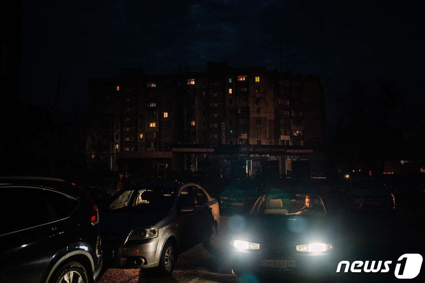 본문 이미지 - 26일 &#40;현지시간&#41; 우크라이나 미콜라이우에서 정전의 어둠 속에 주민이 주차장서 차량을 타고 있다. ⓒ AFP=뉴스1 ⓒ News1 우동명기자