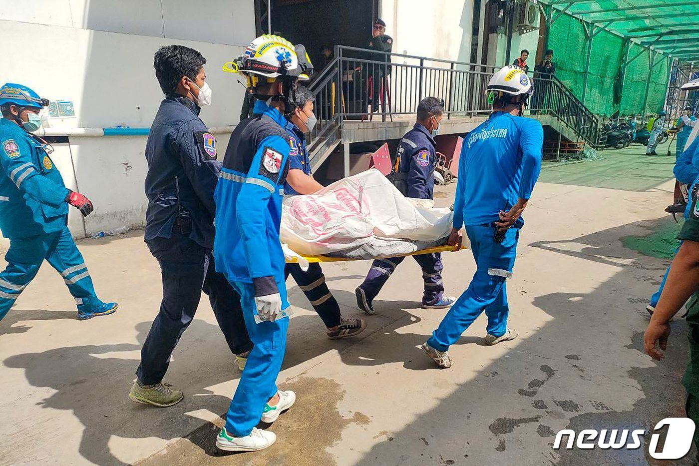 본문 이미지 - 29일 (현지시간) 캄보다아 포이펫에 있는 그랜드 다이아몬드 시티 호텔 카지노에서 대형 화재가 발생한 현장서 구조대원이 희생자를 이송하고 있다. ⓒ AFP=뉴스1 ⓒ News1 우동명 기자