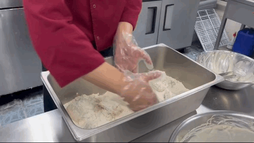 본문 이미지 - 물반죽을 입힌 닭에 파우더를 묻혀주고 있다. ⓒ News1 신민경 기자