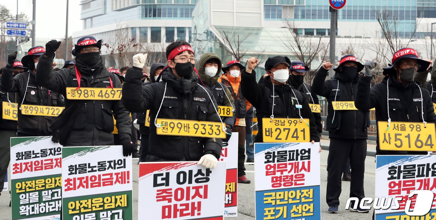 본문 이미지 - 7일 오후 세종시 정부세종청사 국토교통부 앞에서 열린 민주노총 공공운수노조 화물연대본부 집회에서 노조원들이 화물차 번호판을 목에 걸고 정부의 업무개시명령을 규탄하며 안전운임제 일몰제 폐지 등을 요구하고 있다. 2022.12.7/뉴스1 ⓒ News1 김기남 기자