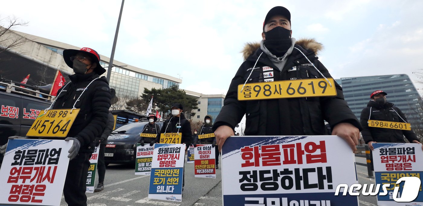 본문 이미지 - 7일 오후 세종시 정부세종청사 국토교통부 앞에서 열린 민주노총 공공운수노조 화물연대본부 집회에서 노조원들이 화물차 번호판을 목에 걸고 정부의 업무개시명령을 규탄하며 안전운임제 일몰제 폐지 등을 요구하고 있다. 2022.12.7/뉴스1 ⓒ News1 김기남 기자