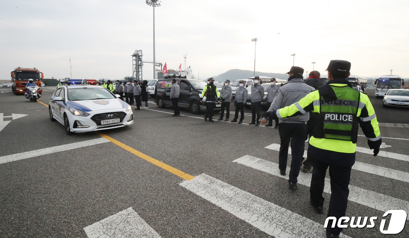 (제주=뉴스1) 오현지 기자 = 화물연대 총파업 후 처음으로 제주지역에 시멘트가 반입된 8일 오전 제주시 애월항에서 시멘트를 싣고 읻동하는 벌크시멘트트레일러(BCT) 차량을 경찰이 …