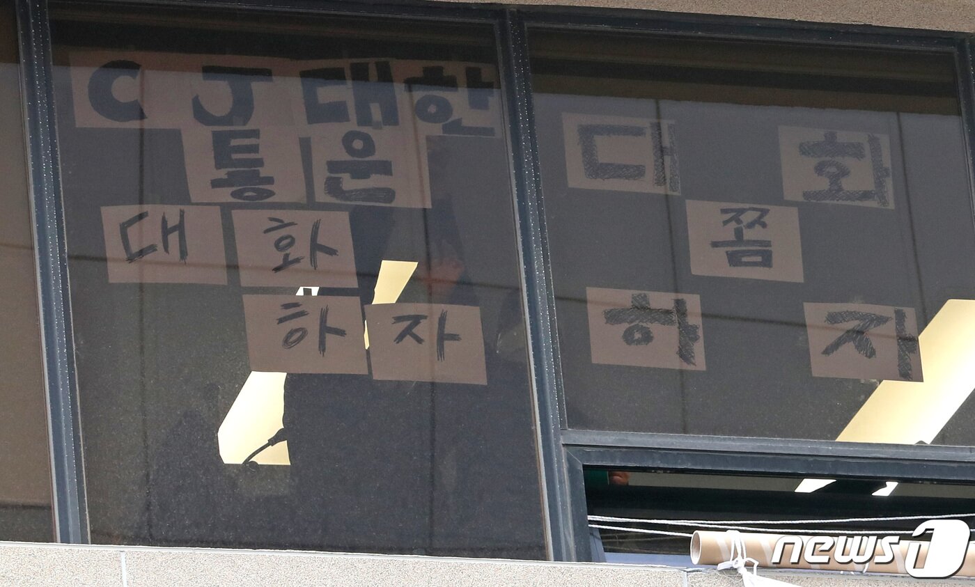 본문 이미지 - 11일 서울 중구 CJ대한통운 본사에서 민주노총 전국택배노동조합(택배노조)이 창문에 문구를 붙이고 있다. 택배노조는 파업 45일째인 지난 10일 CJ대한통운 본사를 기습 점거해 농성에 돌입했다. 2022.2.11/뉴스1 ⓒ News1 이성철 기자