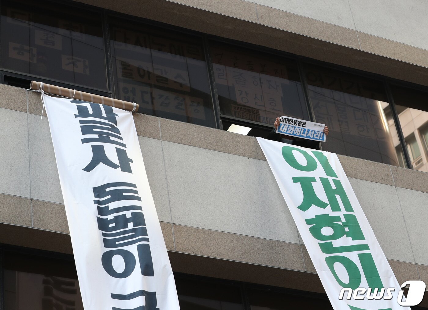 본문 이미지 - 11일 서울 중구 CJ대한통운 본사에서 민주노총 전국택배노동조합(택배노조)이 창문 사이로 구호를 외치고 있다. 택배노조는 파업 45일째인 지난 10일 CJ대한통운 본사를 기습 점거해 농성에 돌입했다. 2022.2.11/뉴스1 ⓒ News1 이성철 기자