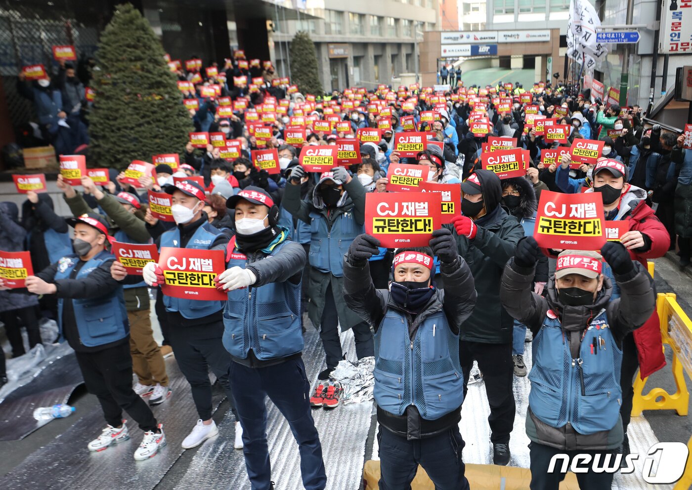 본문 이미지 - 민주노총 조합원들이 11일 서울 중구 CJ대한통운 앞에서 가진 '사회적 합의이행 거부! 택배대란 사태 주범! CJ대벌 규탄! 민주노총 결의대회'에서 손피켓을 들어 보이고 있다. 민주노총은 이날 "사회적 합의 이행을 거부해 택배대란의 주범이 되고 있는 CJ그룹을 규탄하고, CJ대한통운이 대화에 나설 것을 촉구한다＂고 밝히며 결의대회를 진행했다. 2022.2.11/뉴스1 ⓒ News1 이성철 기자