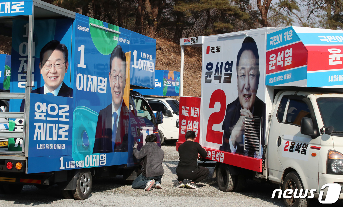 (금산=뉴스1) 김기태 기자 = 제20대 대통령선거 공식선거운동을 앞둔 14일 충남 금산에 위치한 차량광고업체에서 관계자들이 이재명 더불어민주당 대선 후보와 윤석열 국민의힘 대전 …