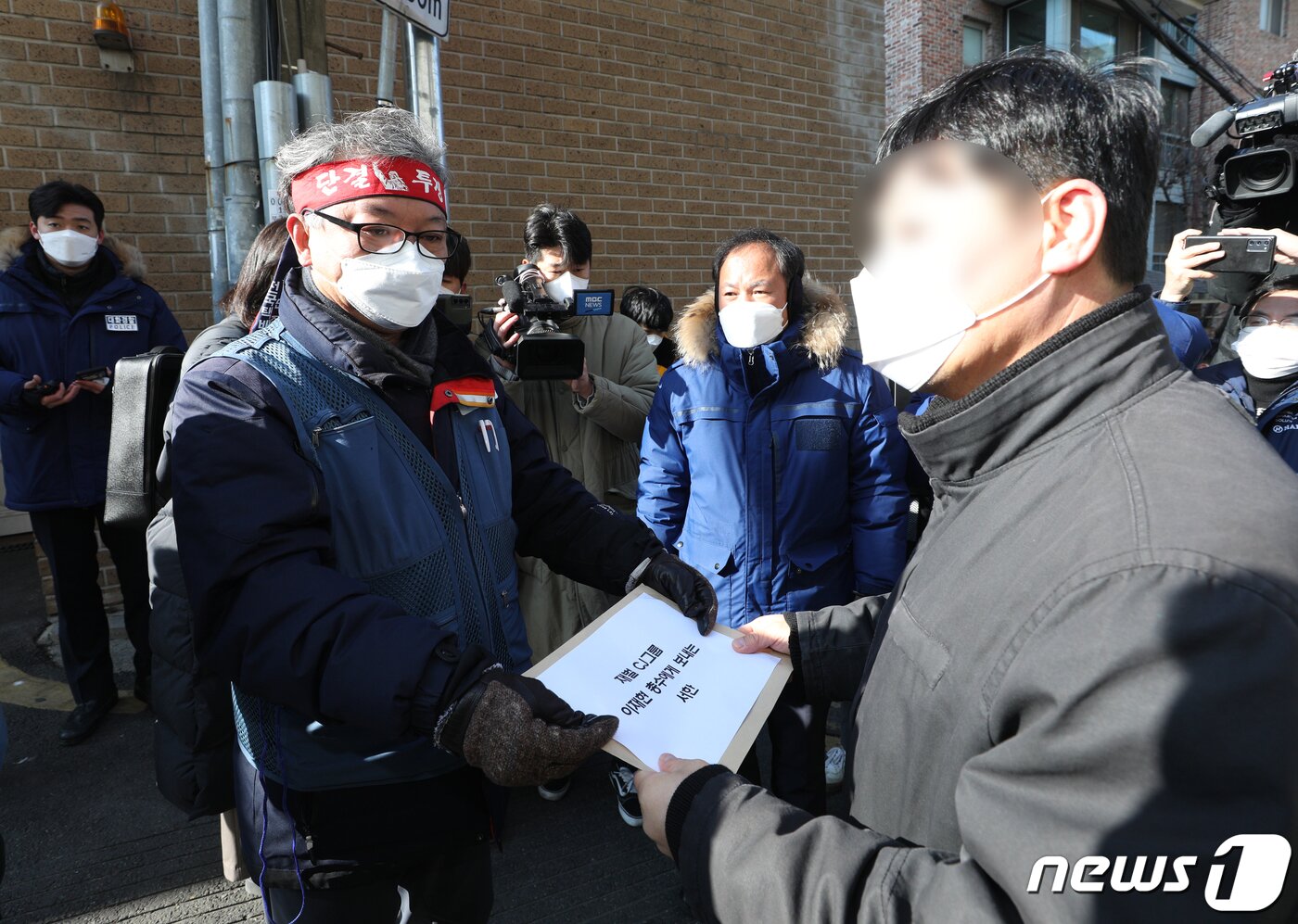 본문 이미지 - 진경호 전국택배노조 위원장이 16일 오전 서울 중구 이재현 CJ 회장 자택 앞에서 관계자에게 이 회장과의 대화를 촉구하는 서한을 전달하고 있다.  2022.2.16/뉴스1 ⓒ News1 신웅수 기자