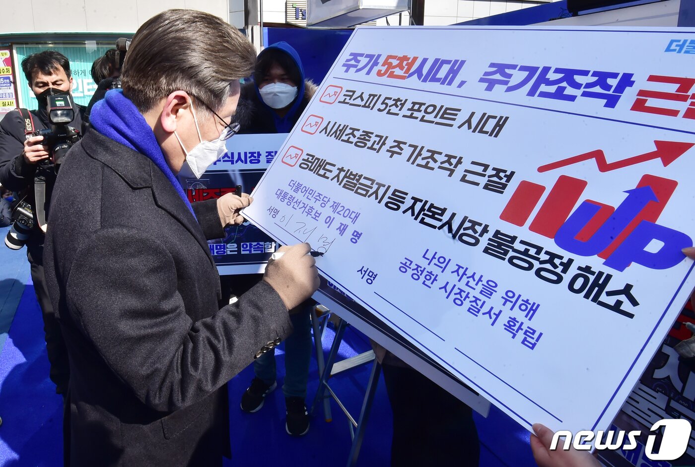 본문 이미지 - 이재명 더불어민주당 대선 후보가 16일 서울 강남구 강남역 인근에서 열린 'JM은 강남스타일!' 선거 유세에서 주가 5천시대, 주가조작 근절 서약서에 서명을 하고 있다. 2022.2.16/뉴스1 ⓒ News1 국회사진취재단