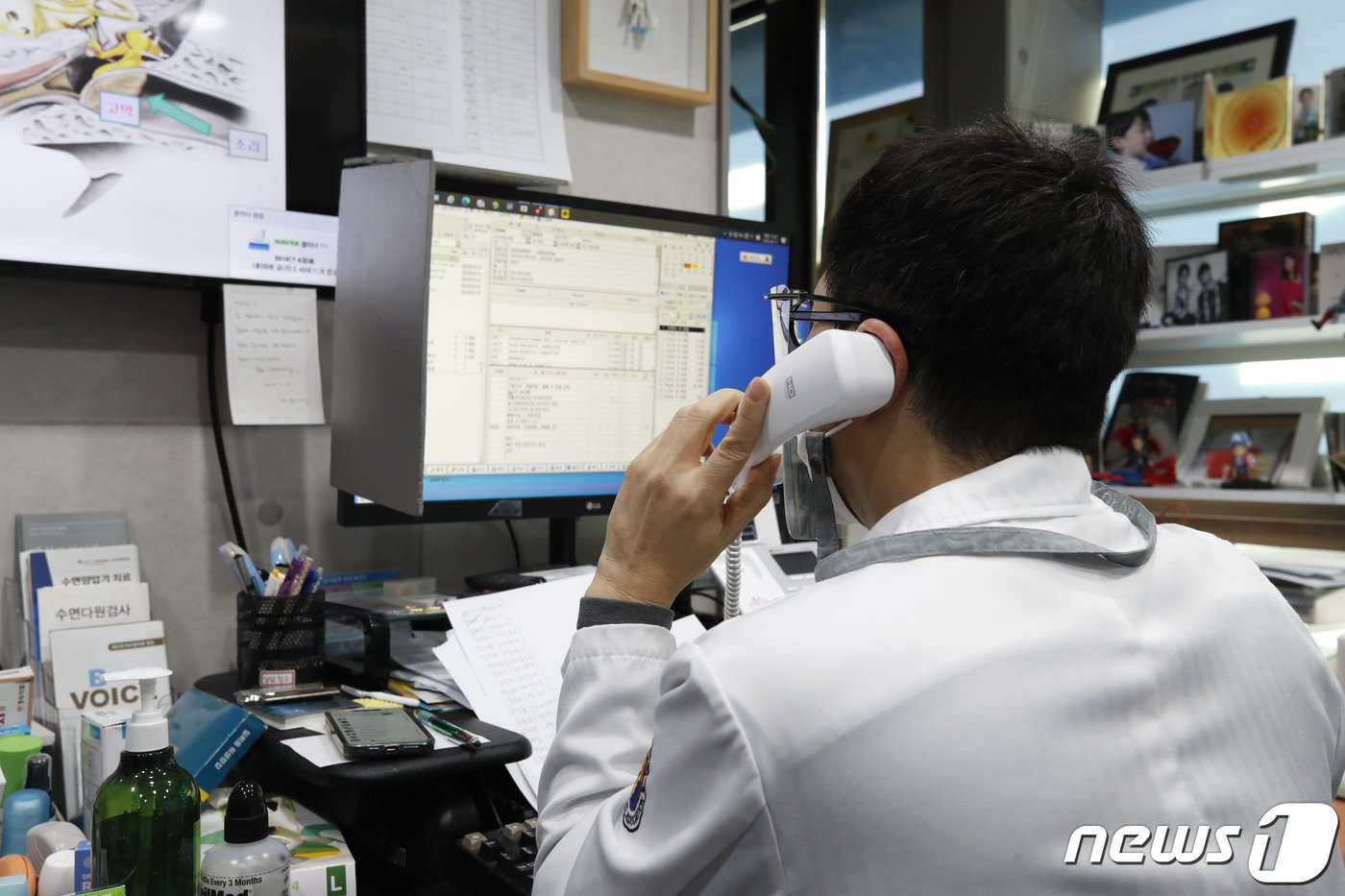본문 이미지 - 17일 서울 중구의 한 이비인후과 병원에서 의료진이 코로나19 확진 판정을 받은 환자에게 전화 걸어 비대면 진료를 보고 있다. 2022.2.17/뉴스1 ⓒ News1 임세영 기자