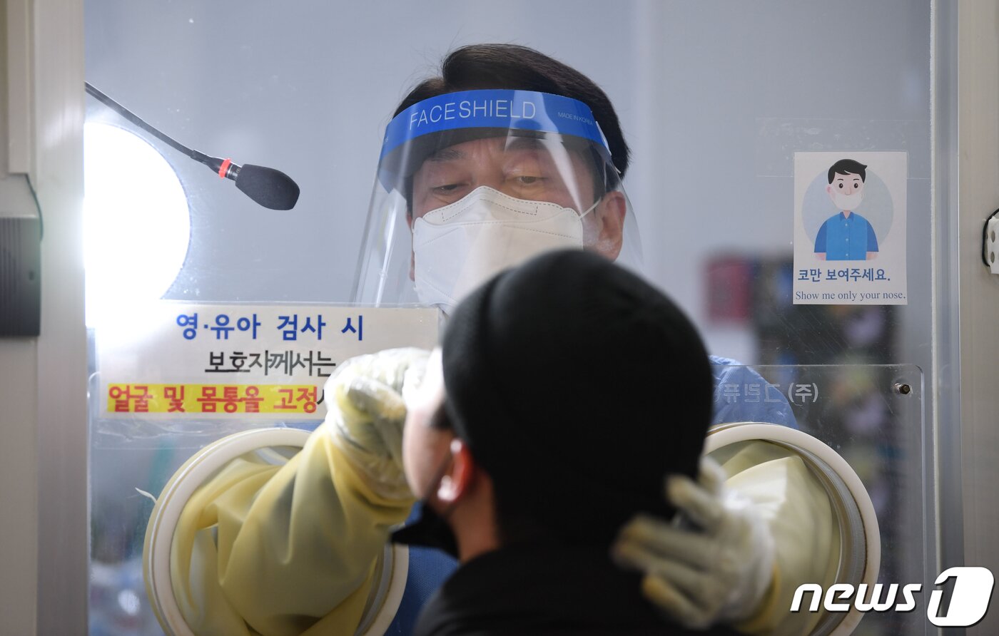 본문 이미지 - 안철수 국민의당 대선 후보가 설 연휴 마지막 날인 2일 서울 중구보건소 선별진료소에서 부인 김미경 교수와 함께 코로나19 검체 채취 의료봉사 활동을 하고 있다. 이날 동행한 딸 안설희 박사는 행정 업무 등을 지원했다. 2022.2.2/뉴스1 ⓒ News1 오대일 기자