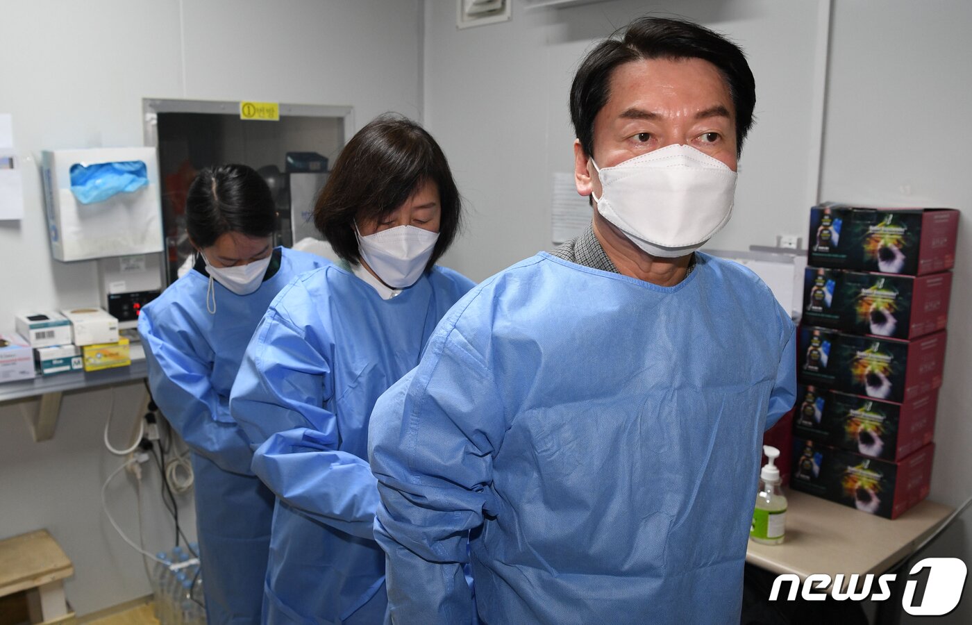 본문 이미지 - 안철수 국민의당 대선 후보가 설 연휴 마지막 날인 2일 서울 중구보건소 선별진료소에서 부인 김미경 교수, 딸 안설희 박사와 함께 코로나19 의료 봉사를 위해 가운을 착용하고 있다. 이날 안 후보 부부는 검체 체취를, 딸 안설희 박사는 행정 업무 등을 지원했다. 2022.2.2/뉴스1 ⓒ News1 오대일 기자