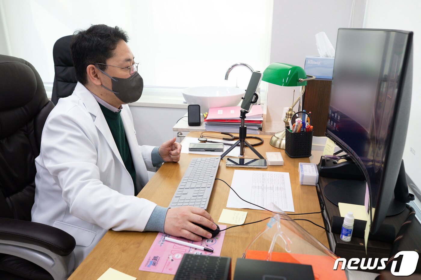 본문 이미지 - 22일 '소아전용' 의료상담센터인 서울 서초구 연세곰돌이소아청소년과의원에서 송종근 대표원장이 신종 코로나바이러스 감염증(코로나19) 재택치료 중인 소아의 보호자와 통화하며 비대면진료를 하고 있다. 2022.2.22/뉴스1 ⓒ News1 유승관 기자