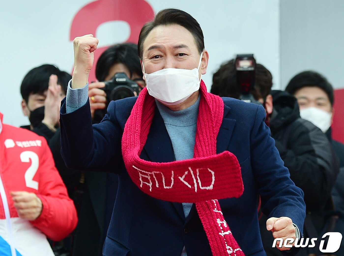 본문 이미지 - 윤석열 국민의힘 대선 후보가 22일 오후 충남 홍성군 내포신도시에서 열린 거점유세에서 지지자에게 받은 빨간 목도리를 두르고 '어퍼컷 세리머니'를 하고 있다. 윤 후보는 이날부터 1박 2일 동안 서해안 라인을 따라 충남·전북·전남을 차례로 방문하며 거점 유세를 벌인다. 2022.2.22/뉴스1 ⓒ News1 구윤성 기자
