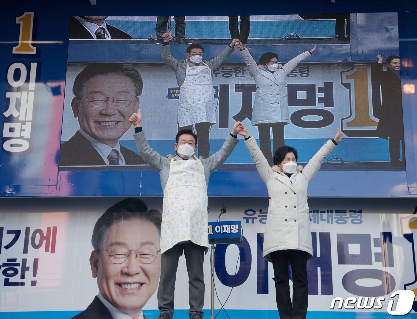 본문 이미지 - 이재명 더불어민주당 대선 후보가 22일 오후 인천 부평역 앞 광장에서 열린 '인천 재도약 앞으로, 인천 경제 제대로!' 부평 유세에서 시장 상인이 선물한 앞치마를 착용한 뒤 손을 들어보이고 있다. 2022.2.22/뉴스1 ⓒ News1 국회사진취재단