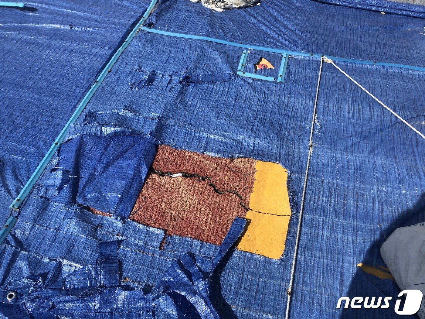 본문 이미지 - 부산 영도 한 신축 아파트의 도시계획시설인 도로가 갈라져 파란색 천막으로 덮어놓고 있다..2022.2.22/ⓒ 뉴스1 백창훈 기자