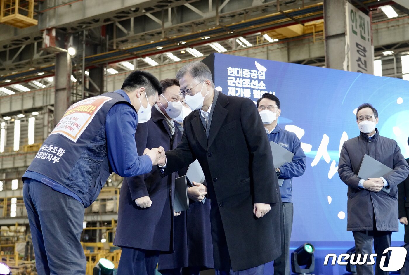 본문 이미지 - 문재인 대통령이 지난 2월24일 전북 군산시 현대중공업 군산조선소에서 열린 군산조선소 재가동 협약식에 참석해 협약식을 마친뒤 정병천 현대중공업 노조지부장과 주먹인사를 하고 있다. 2022.2.24/뉴스1 ⓒ News1 이광호 기자