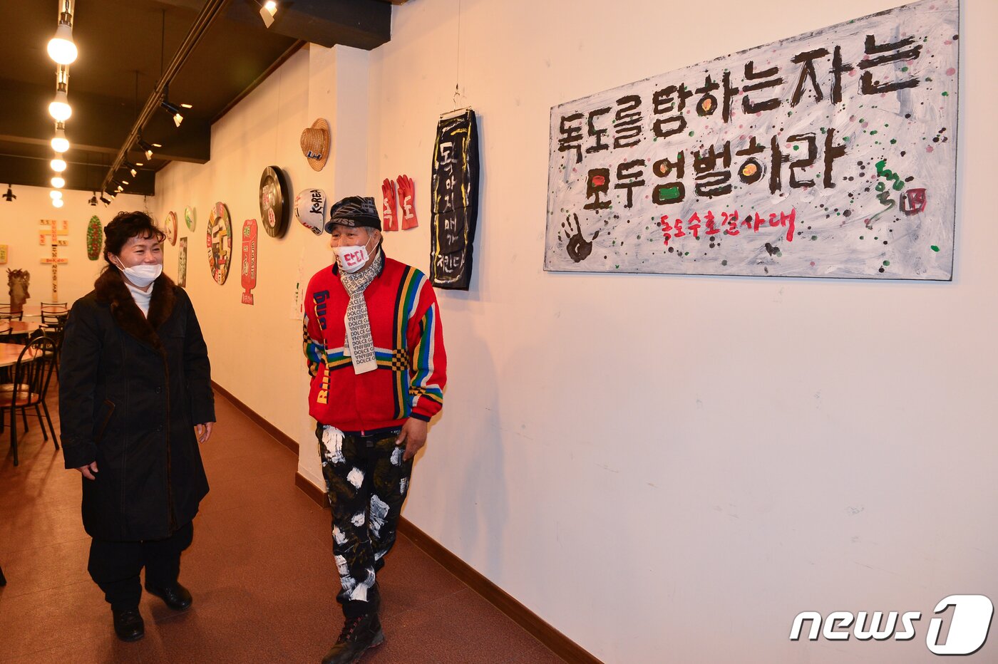 본문 이미지 - 25일 제103주년 3.1절을 맞아 경북 포항시 북구 기계면 봉좌마을에서 열린 독도 사랑 작품전에서 독도사랑예술인연협회 김지영 회장과 서예가이자 독도수호결사대장인 김동욱씨가 작품을 둘러보고 있다. 이번 작품전에는 도예가 박종일 선생이 직접 구운 달항어리 등도 전시되고 있다. 작품전은 25일부터 다음달 7일까지 10일간 무료로 열린다. 2022.2.25/뉴스1 ⓒ News1 최창호 기자