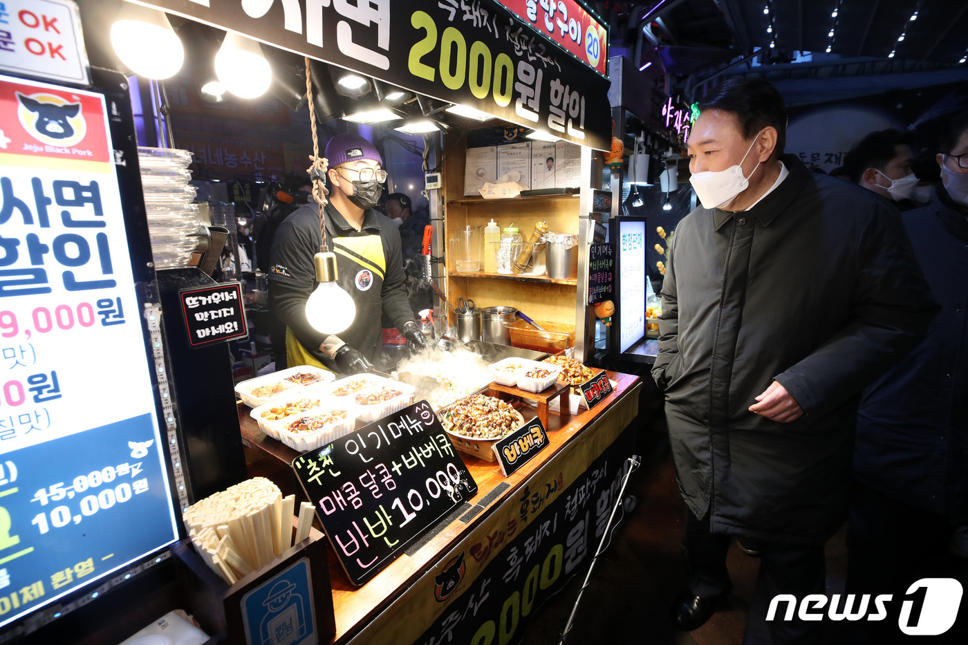 (제주=뉴스1) 구윤성 기자 = 윤석열 국민의힘 대선 후보가 5일 오후 제주 동문시장을 방문해 음식을 구입하고 있다. 2022.2.5/뉴스1