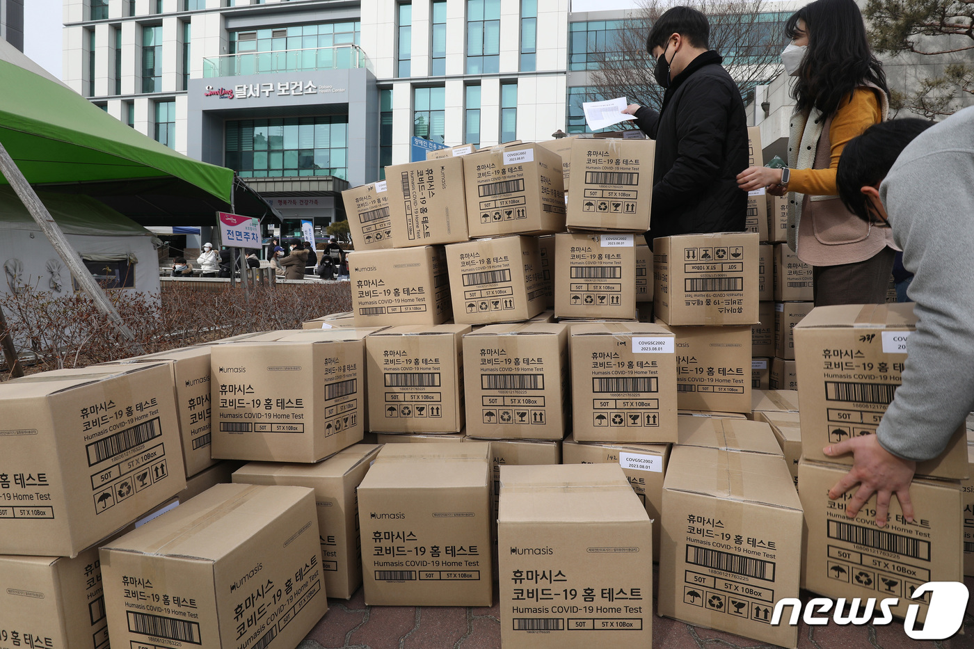 (대구=뉴스1) 공정식 기자 = 7일 오전 대구 달서구보건소 선별진료소 앞에서 보건소 및 구청 관계자들이 신속항원검사에 필요한 코로나19 자가진단키트를 옮기고 있다. 2022.2. …