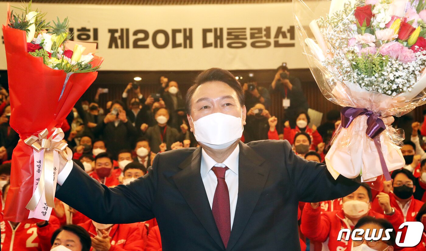 본문 이미지 - 윤석열 대통령 당선인이 10일 새벽 서울 여의도 국회도서관에 마련된 '국민의힘 제 20대 대통령선거 개표상황실'을 찾아 꽃다발을 받고 있다. 2022.3.10/뉴스1 ⓒ News1 구윤성 기자