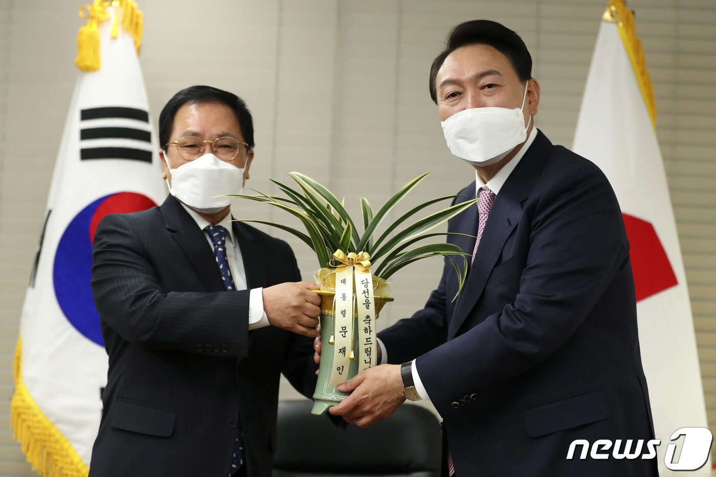 본문 이미지 - 윤석열 대통령 당선인이 10일 오후 서울 여의도 국민의힘 당사에서 유영민 대통령 비서실장에게 문재인 대통령의 축하난을 받고 있다. 2022.3.10/뉴스1 ⓒ News1 이동해 기자