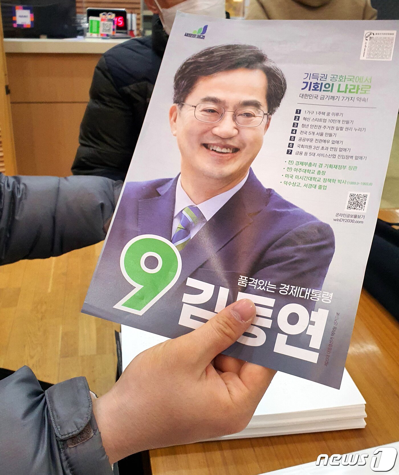 본문 이미지 - 지난 4일 시각장애인 권남희씨(30)가 김동연 새로운물결 후보가 배포한 공보물을 들어보이고 있다. 김 후보는 공보물에 시각장애인용 QR코드를 첨부하기는 했지만 권씨는 QR코드만 기재한 경우 시각장애인 혼자 이를 확인하기는 어렵다고 말했다. ⓒ 뉴스1