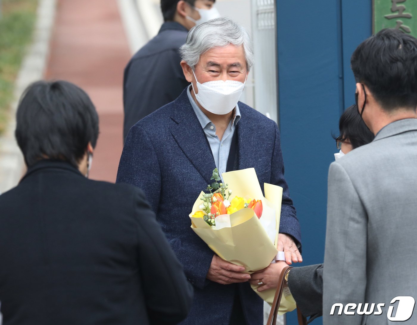 본문 이미지 - 최경환 전 경제부총리가 17일 오전 경기 안양교도소에서 가석방으로 출소하며 지지자들에게 꽃다발을 받고 있다. 2022.3.17/뉴스1 ⓒ News1 김영운 기자