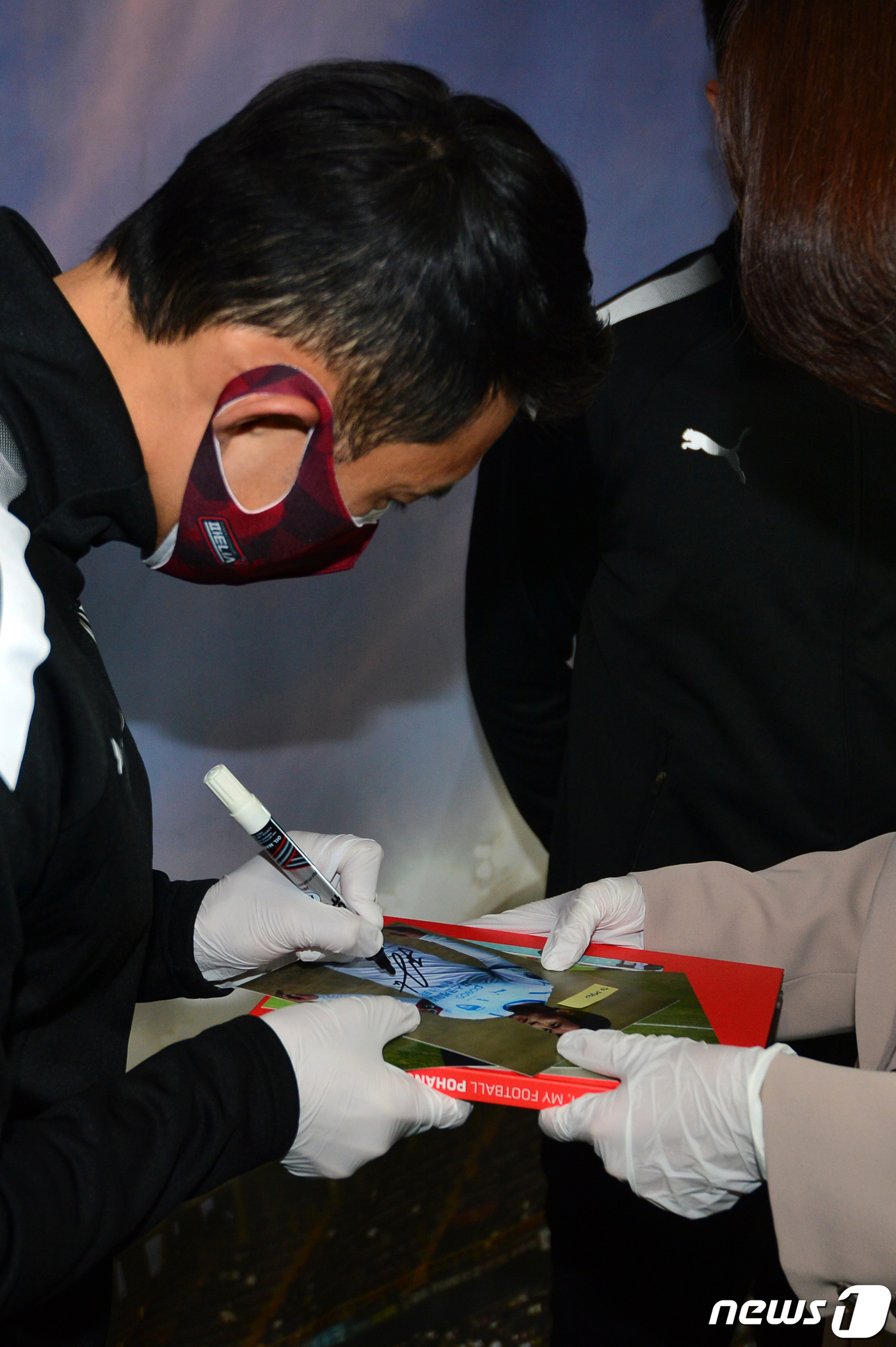 (포항=뉴스1) 최창호 기자 = 신진호 프로축구 포항 스틸러스 선수가 17일 포항시청 로비에서 열린 2022 포항스틸러스 시즌카드 판매행사에서 팬이 건넨 자신의 사진에 사인하고 있 …