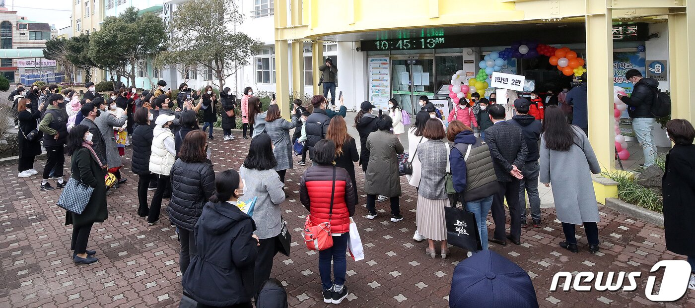 본문 이미지 - 새 학기 전면 등교 첫 날인 2일 오전 제주시 월랑초등학교 현관 앞에서 학부모들이 입학식을 마치고 나온 자녀들을 맞이하고 있다.2022.3.2/뉴스1 ⓒ News1 오현지 기자