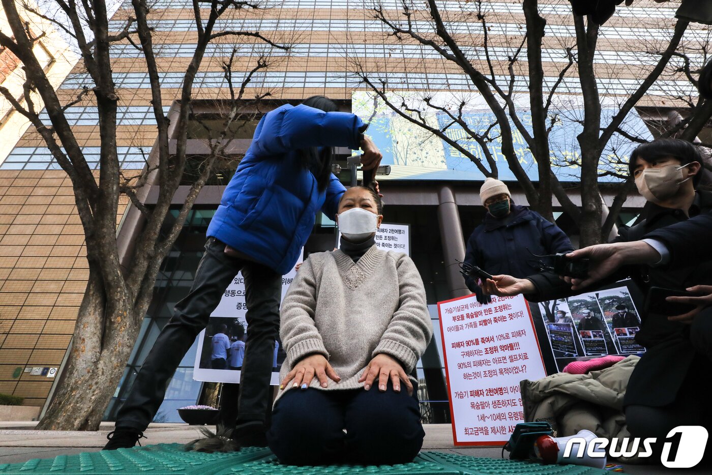 본문 이미지 - 가습기살균제 피해자 가족이 22일 서울 종로구 광화문 교보빌딩 앞에서 가습기 살균제 참사 조정위의 불합리한 조정안 개선을 요구하며 삭발식을 하고 있다. 2022.3.22/뉴스1 ⓒ News1 성동훈 기자