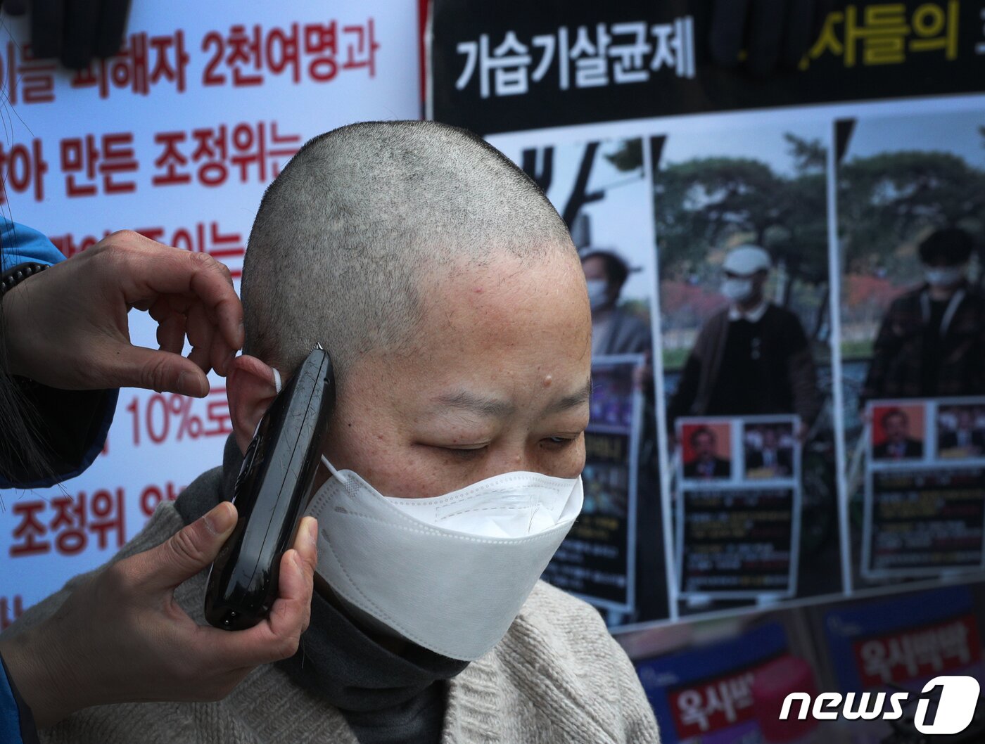 본문 이미지 - 가습기살균제 피해자 가족이 광화문 교보빌딩 앞에서 가습기 살균제 참사 조정위의 조정안 개선을 요구하며 삭발하고 있다. 2022.3.22/뉴스1