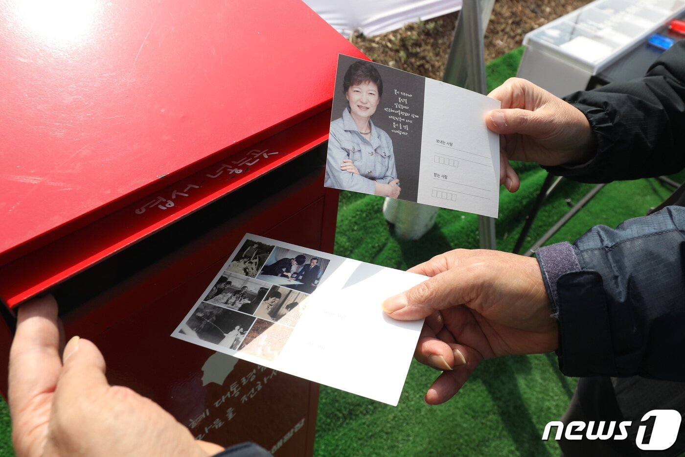 본문 이미지 - 22일 대구 달성군 유가읍 박근혜 전 대통령 사저를 찾은 방문객들이 사저 입구에 마련된 기념엽서를 보내고 있다. 2022.3.22/뉴스1 ⓒ News1 공정식 기자