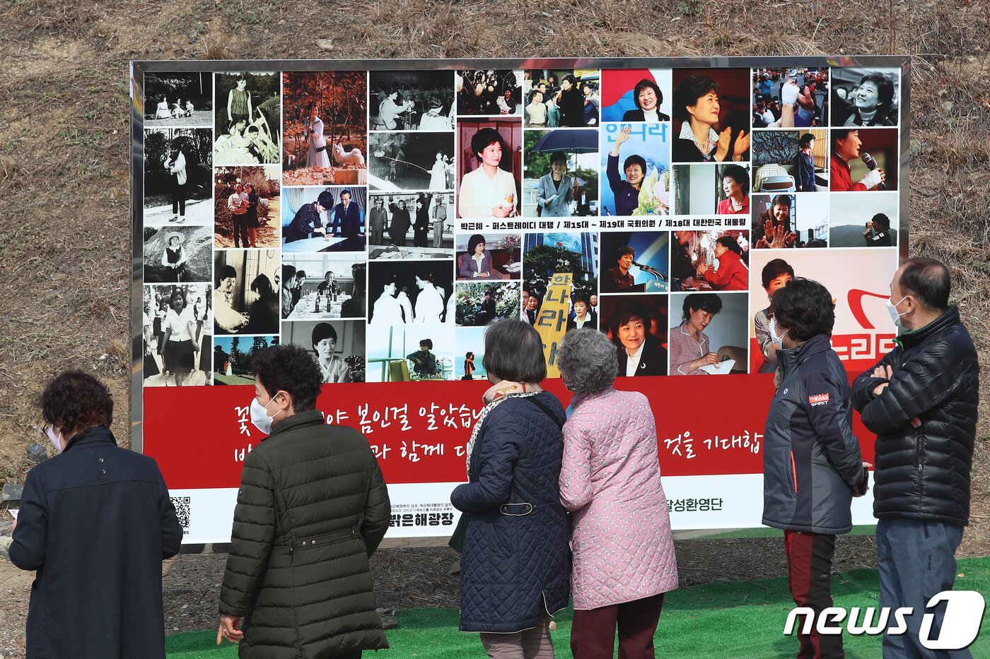 본문 이미지 - 박근혜 전 대통령 귀향과 입주를 하루 앞둔 23일 오후 지지자들이 사저 앞 게시대에 전시된 박 전 대통령 사진을 살펴보고 있다. 2022.3.23/뉴스1 ⓒ News1 공정식 기자