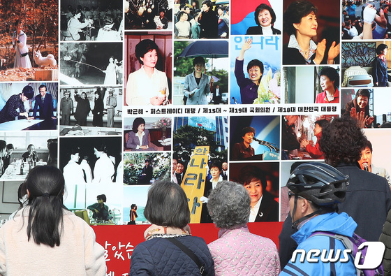 박근혜 전 대통령 귀향과 입주를 하루 앞둔 23일 오후 지지자들이 사저 앞 게시대에 전시된 박 전 대통령 사진을 살펴보고 있다. 2022.3.23/뉴스1 © News1 공정식 기자