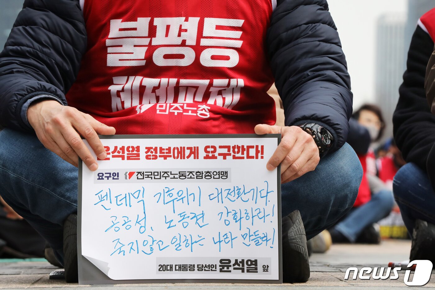 본문 이미지 - 민주노총 조합원들이 24일 오후 서울 중구 청계광장에서 열린 '민주노총 투쟁선포 단위노조 대표자 결의대회'에서 윤석열 대통령 당선인에게 요구하는 메시지를 들어보이고 있다. 이날 민주노총은 결의대회를 통해 윤 대통령 당선인에게 노동 중심의 국정 운영 등을 촉구했다. 2022.3.24/뉴스1 ⓒ News1 황기선 기자