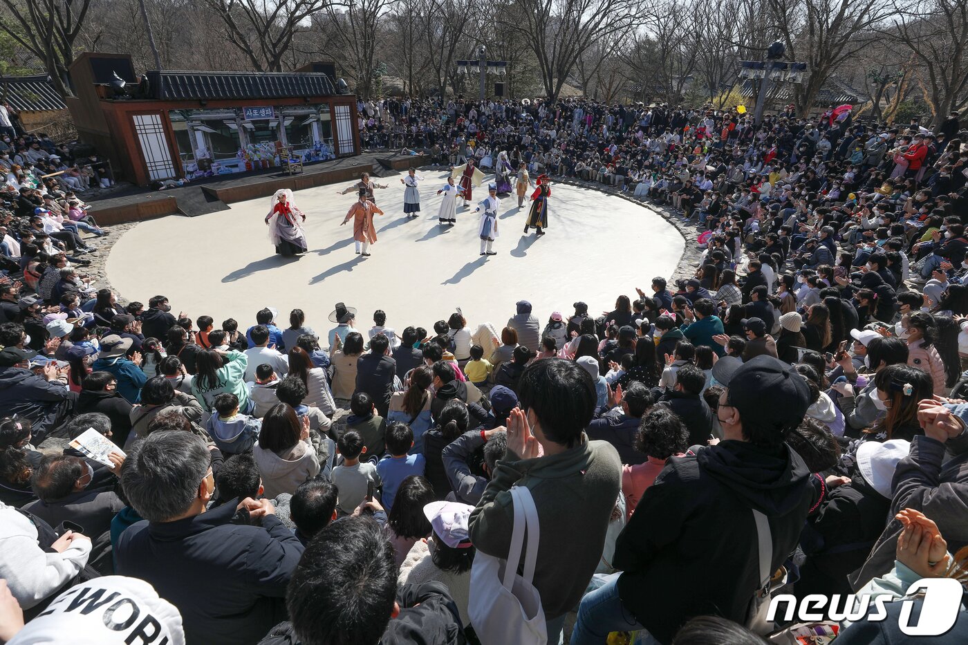 본문 이미지 - 27일 오후 경기도 용인시 한국민속촌을 찾은 시민들이 봄 축제 '웰컴 투 조선'을 맞아 열린 마당극을 관람하고 있다. 2022.3.27/뉴스1 ⓒ News1 민경석 기자