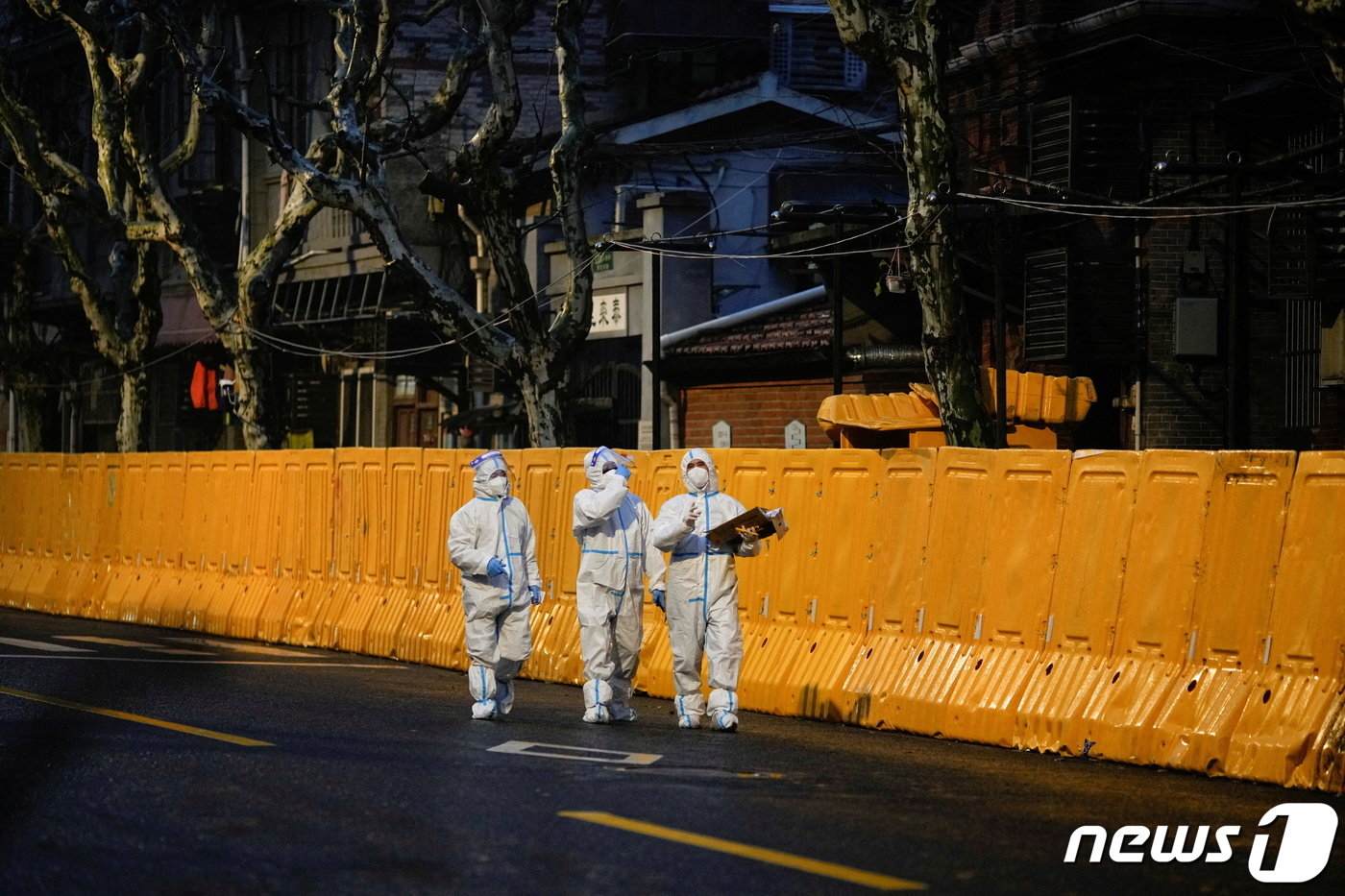 본문 이미지 - 25일 코로나19가 대유행인 중국 상하이에서 개인보호장비&#40;PPE&#41;를 착용한 의료진들이 봉쇄된 지역의 장벽 앞을 걷고 있다. ⓒ 로이터=뉴스1 ⓒ News1 정수영 기자