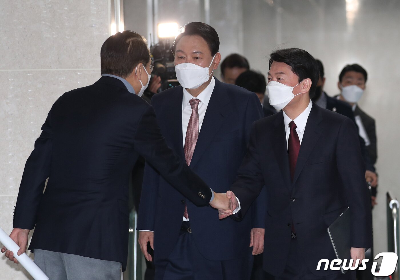 본문 이미지 - 야권 단일화에 전격 합의한 윤석열 국민의힘 대선 후보와 안철수 국민의당 대선 후보가 3일 오전 서울 여의도 국회 소통관으로 공동 기자회견을 하기위해 들어오며 권영세 국민의힘 총괄선대본부장과 악수를 하고 있다. 2022.3.3/뉴스1 ⓒ News1 이동해 기자