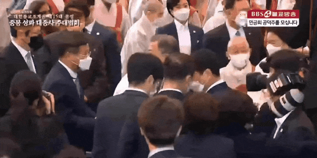 본문 이미지 - 문재인 대통령이 이준석 국민의힘 대표 등을 살짝 친 뒤 악수를 청하는 모습이 포착됐다. (유튜브 BBS 불교방송 갈무리) ⓒ 뉴스1