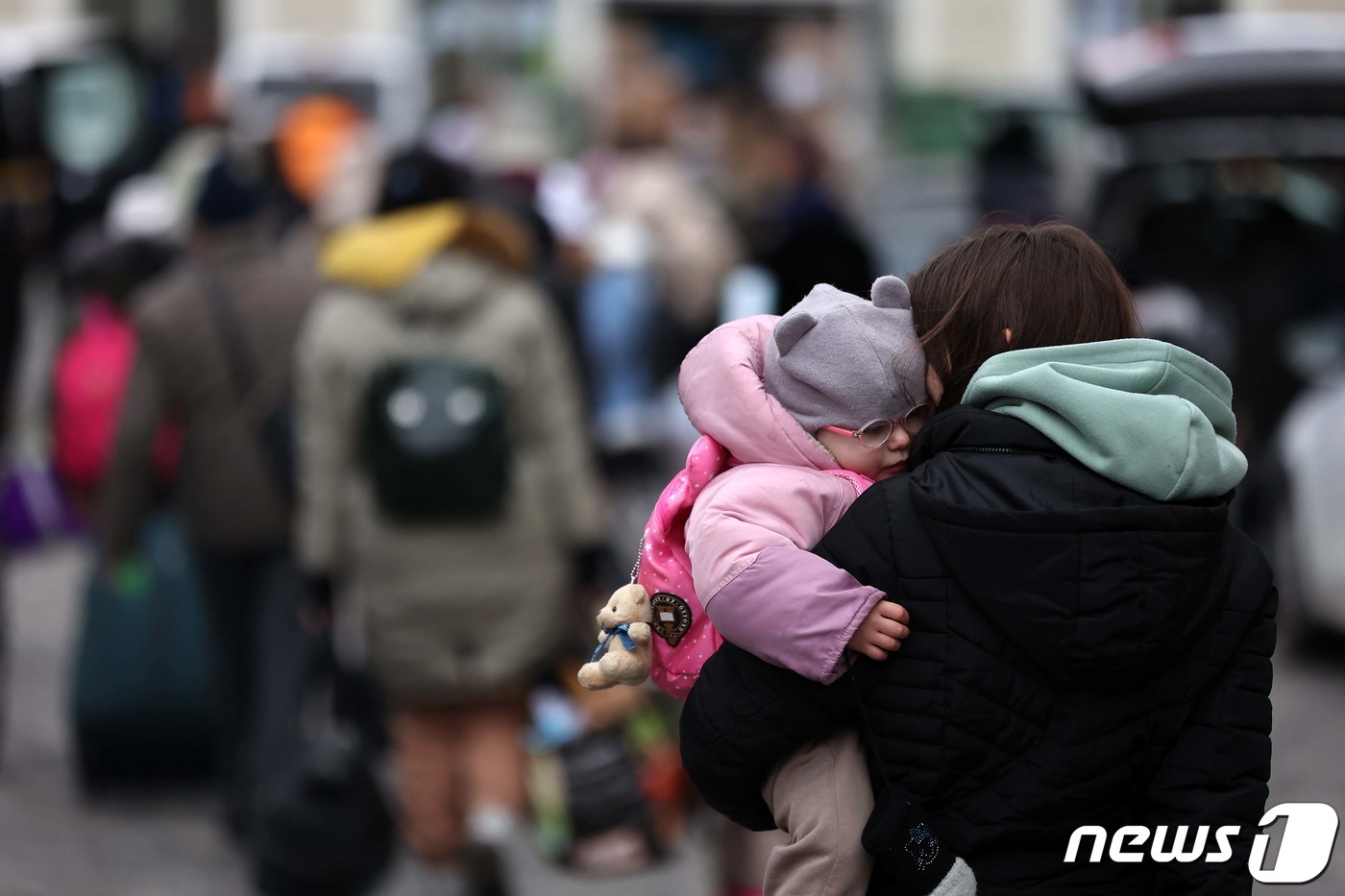 (프셰미실(폴란드)=뉴스1) 조태형 기자 = 6일(현지시간) 우크라이나 접경 도시인 폴란드 프셰미실 중앙역에서 한 피란민이 아이를 안은 채 발걸음을 옮기고 있다. 2022.3.7/ …