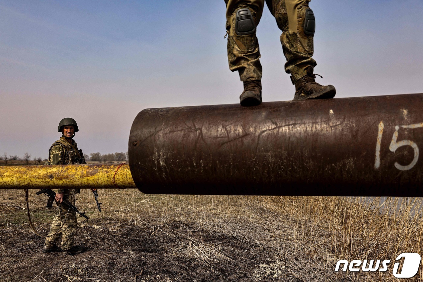 (키이우 AFP=뉴스1) 우동명 기자 = 31일 (현지시간) 우크라이나 수도 키이우 외곽에서 전투를 치른 러시아 군의 파괴된 탱크의 포신에 병사가 올라 서 있다.ⓒ AFP=뉴스1