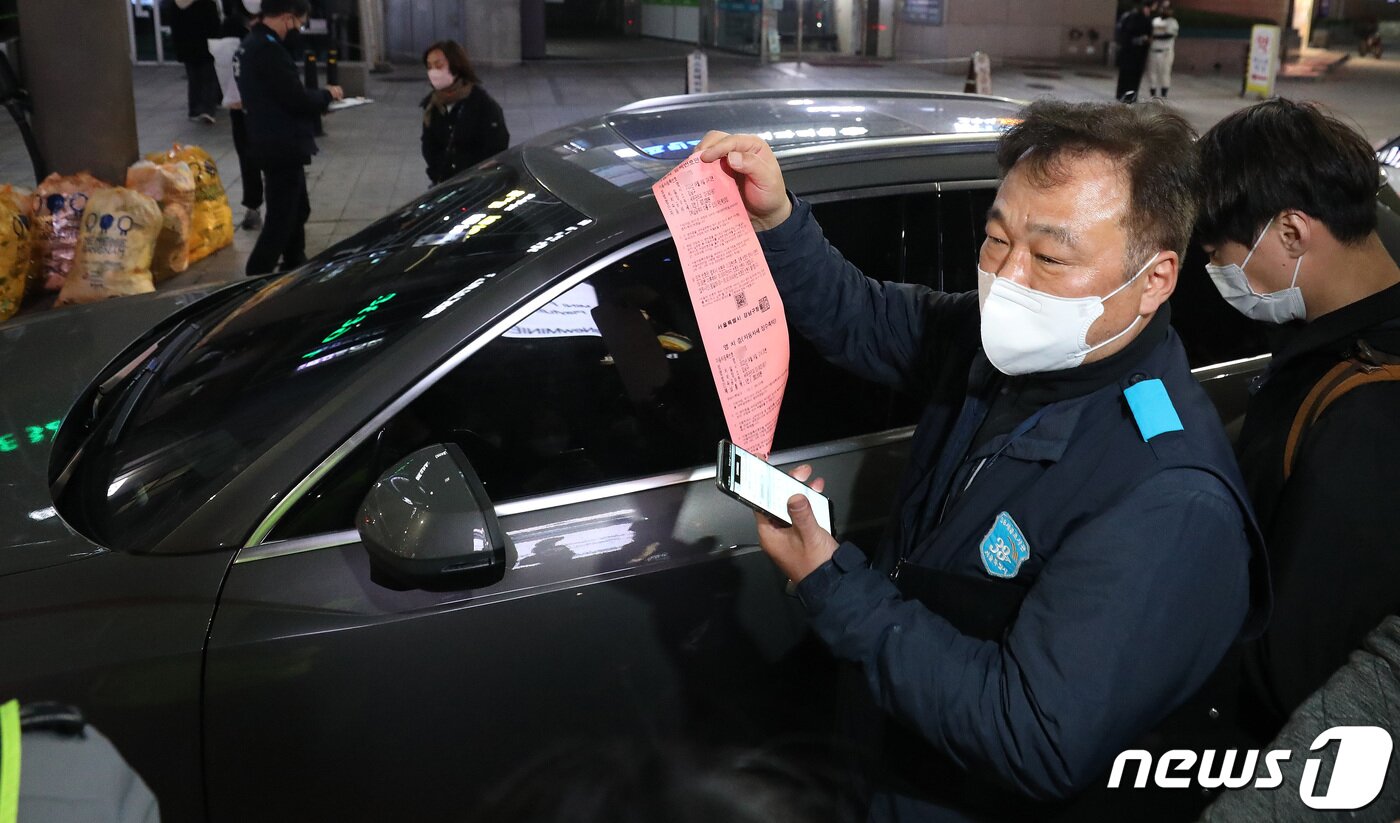 본문 이미지 - 14일 오후 서울 강남구 도산대로 앞에서 서울시세금조사관이 단속된 체납차량의 영치증을 들고 있다. 이날 서울시와 자치구, 경찰청과 한국도로공사 등 4개 기관은 강남과 동대문 일대에서 음주운전 차량과 체납 차량을 합동 단속했다. 단속 대상은 자동차세를 두 번 이상 안 냈거나 과태료 또는 20회 이상 통행료를 체납한 차량, 음주운전자와 대포차 등이다. 서울시는 단속에 적발된 체납 차량은 현장 징수되며, 납부를 거부하면 번호판이 영치되거나 차량이 견인될 수 있다고 강조했다. 2022.4.14/뉴스1 ⓒ News1 박지혜 기자