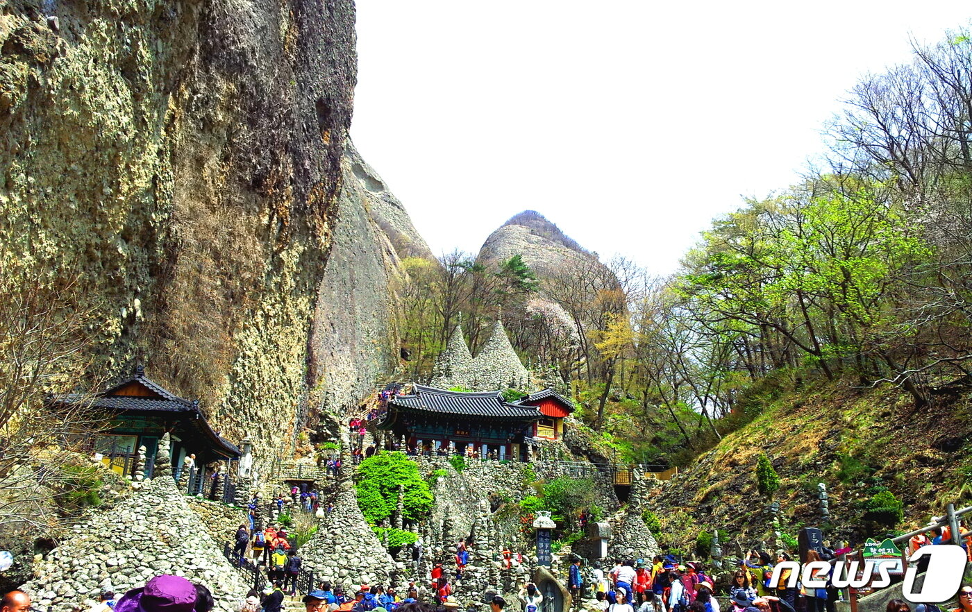 본문 이미지 - 탑사. 80여개의 돌탑으로 꽉 찬 탑사를 둘러보는 탐방객들마다 “이걸 어떻게 쌓았지?”하고 경탄한다. 대웅전 뒤에 두 개의 원뿔형 탑이 천지탑. ⓒ 뉴스1