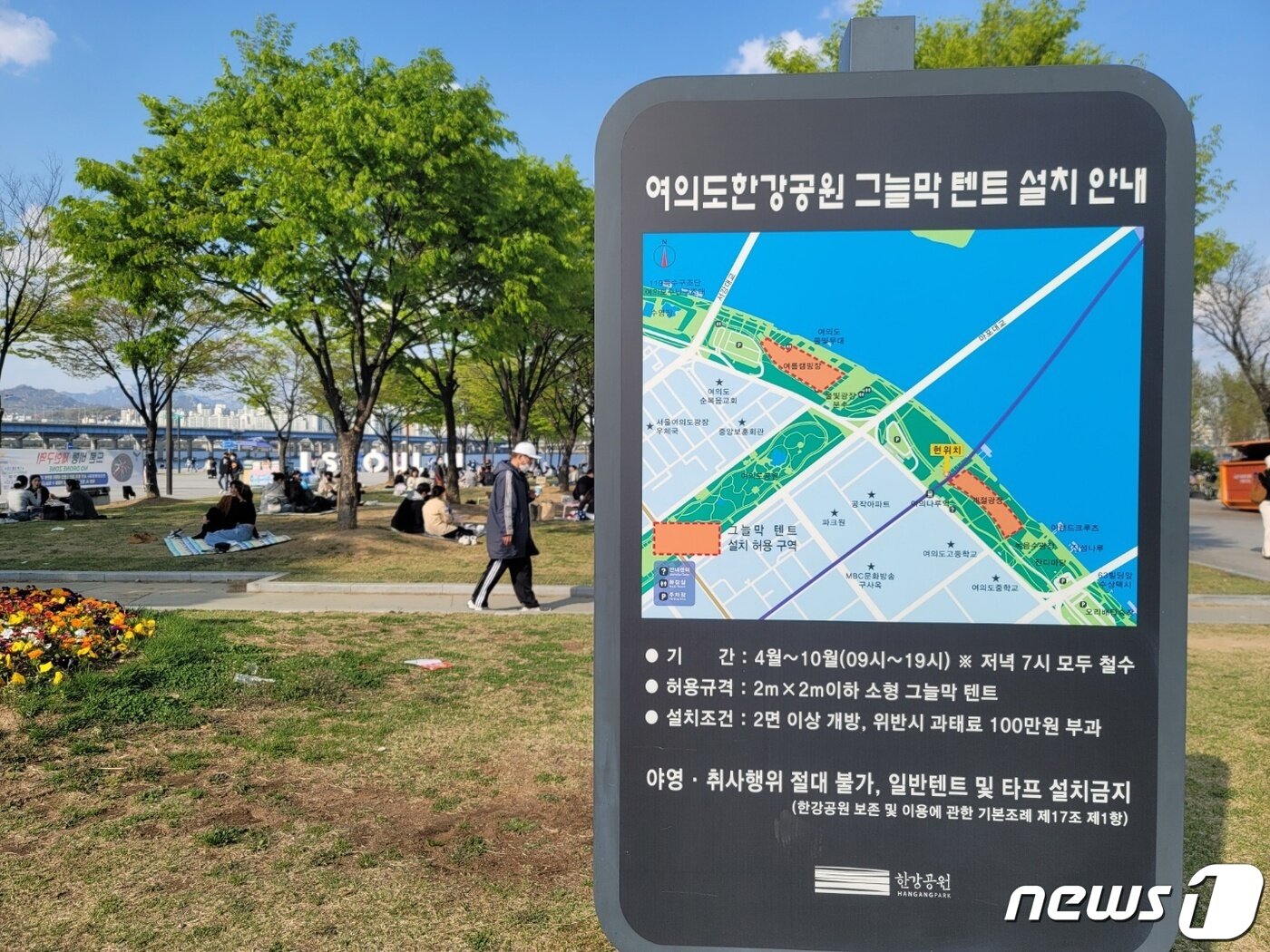 본문 이미지 - 15일 여의도 한강공원 입구 안내판에 4~11월까지 그늘막과 파라솔을 사용할 수 있다는 문구가 새겨져 있다. ⓒ 뉴스1