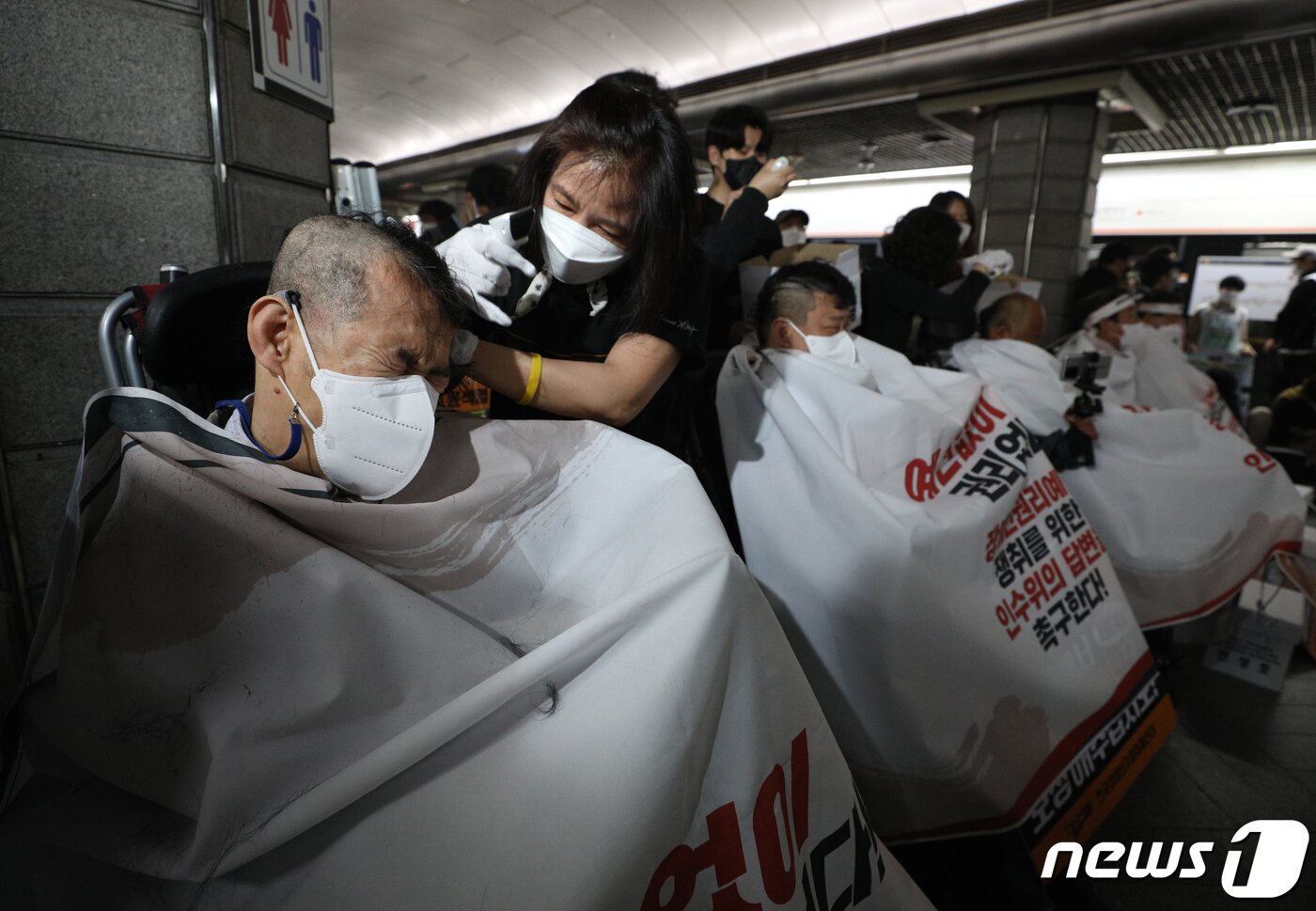 본문 이미지 - 전국장애인차별철폐연대(전장연) 회원들이 20일 오전 서울 경복궁역 3호선 승강장에서 기자회견을 갖고 대통령직 인수위원회의 장애인권리예산 확보를 촉구하며 삭발하고 있다.  2022.4.20/뉴스1 ⓒ News1 신웅수 기자