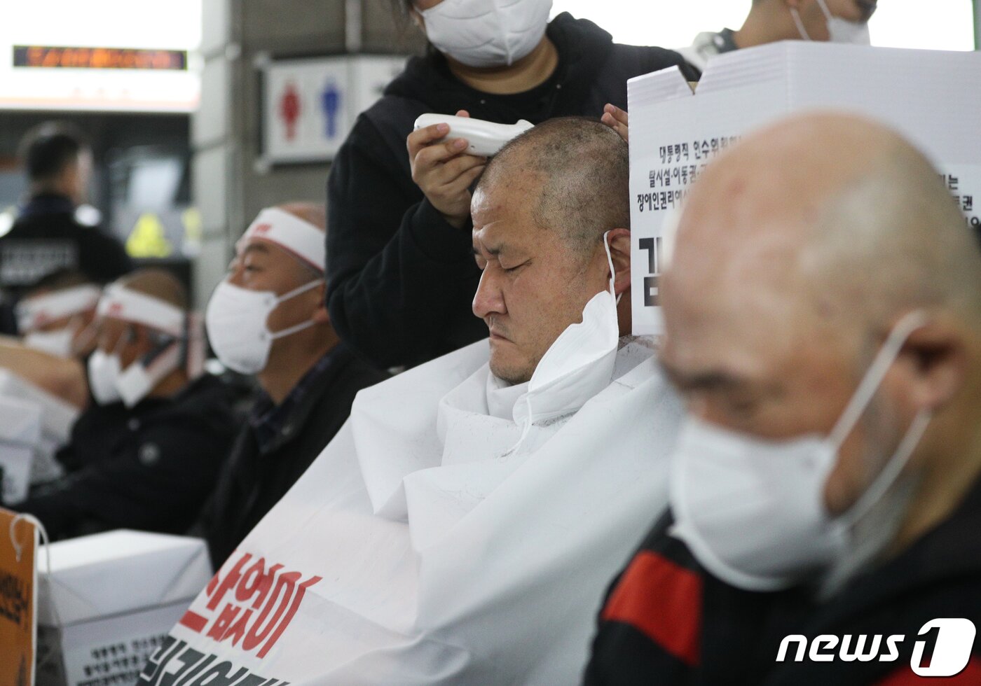 본문 이미지 - 전국장애인차별철폐연대(전장연) 회원들이 20일 오전 서울 경복궁역 3호선 승강장에서 기자회견을 갖고 대통령직 인수위원회의 장애인권리예산 확보를 촉구하며 삭발하고 있다.. 2022.4.20/뉴스1 ⓒ News1 신웅수 기자