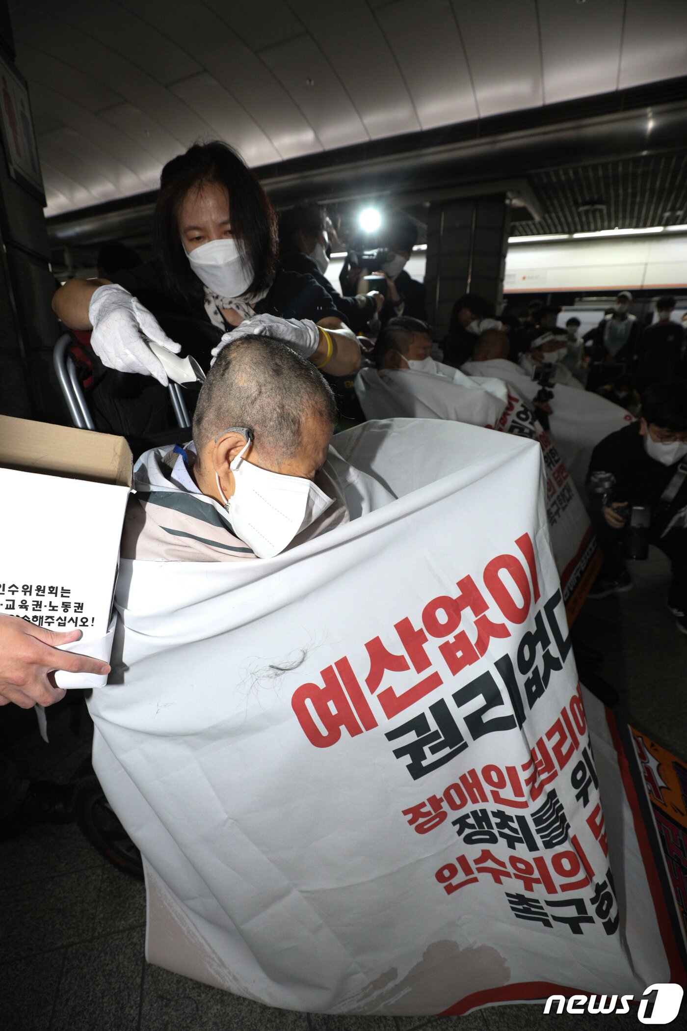 본문 이미지 - 전국장애인차별철폐연대(전장연) 회원들이 20일 오전 서울 경복궁역 3호선 승강장에서 기자회견을 갖고 대통령직 인수위원회의 장애인권리예산 확보를 촉구하며 삭발하고 있다. 2022.4.20/뉴스1 ⓒ News1 신웅수 기자
